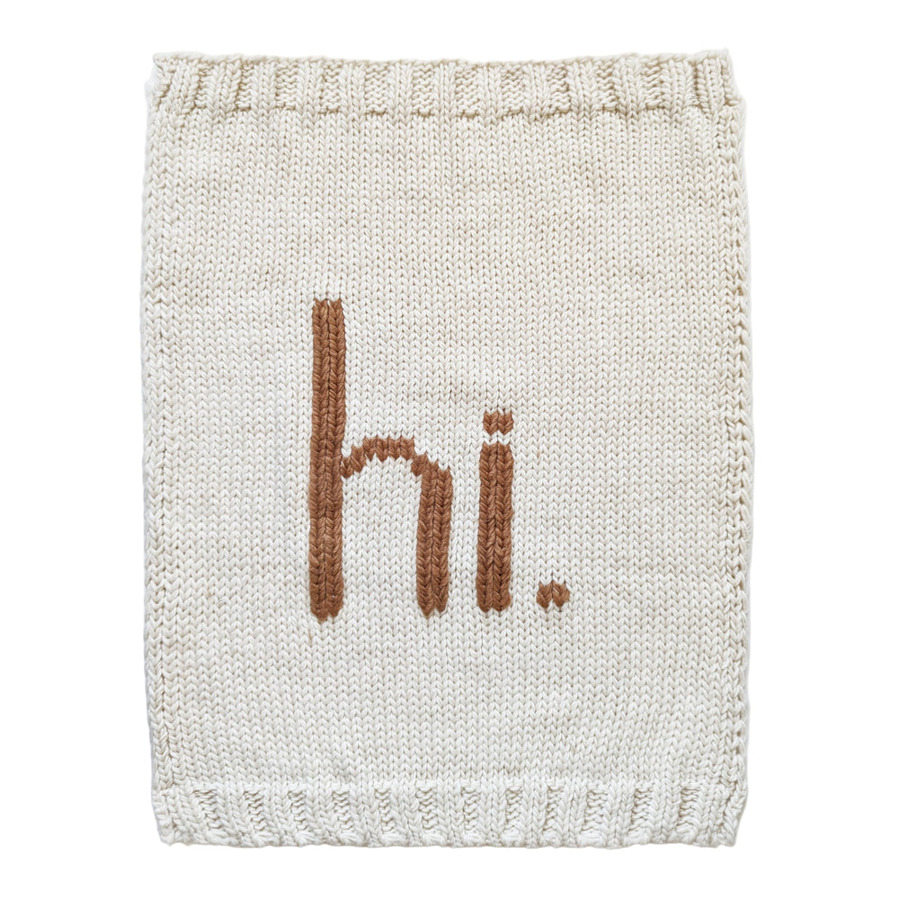 Knitted fabric with 'hi.' text in brown on a white background