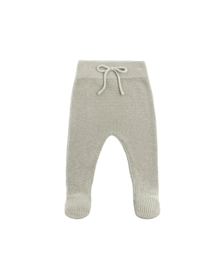 A pair of knit baby booties in a light oatmeal beige color, featuring a textured waffle knit pattern and a matching drawstring waistband, shown against a plain white background.