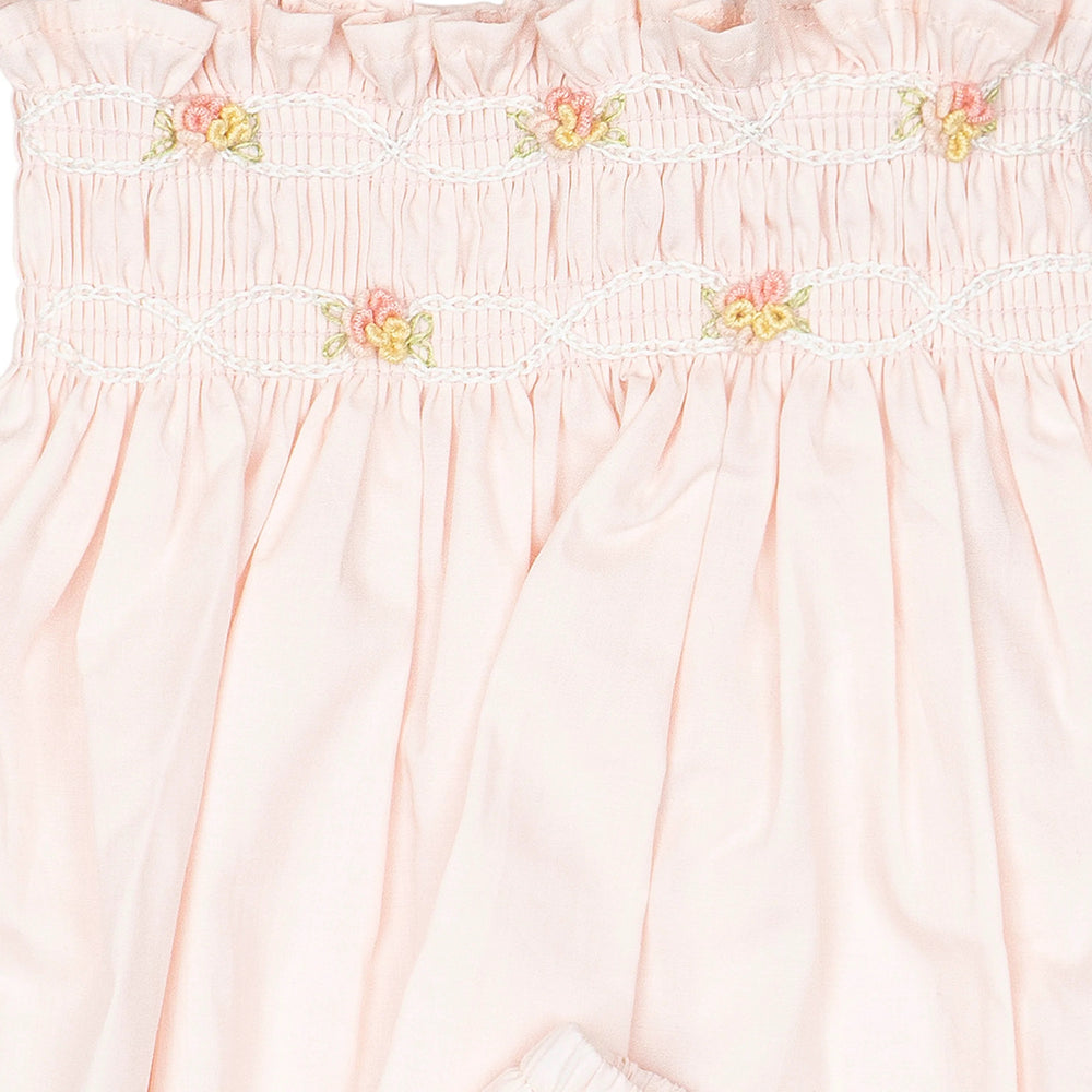 Hand-smocked flutter tunic with embroidered details and matching bloomers in soft pink on a white background.