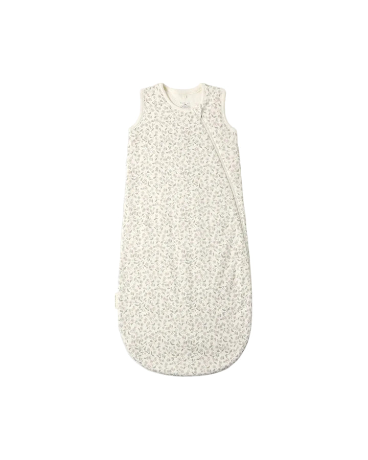 A sleeveless baby sleep bag with a tiny beige and white floral pattern