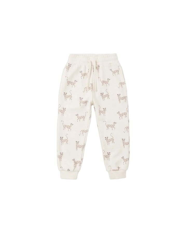 Off-white jogger pants with an allover print of small brown dogs, featuring an elastic waistband and drawstring.