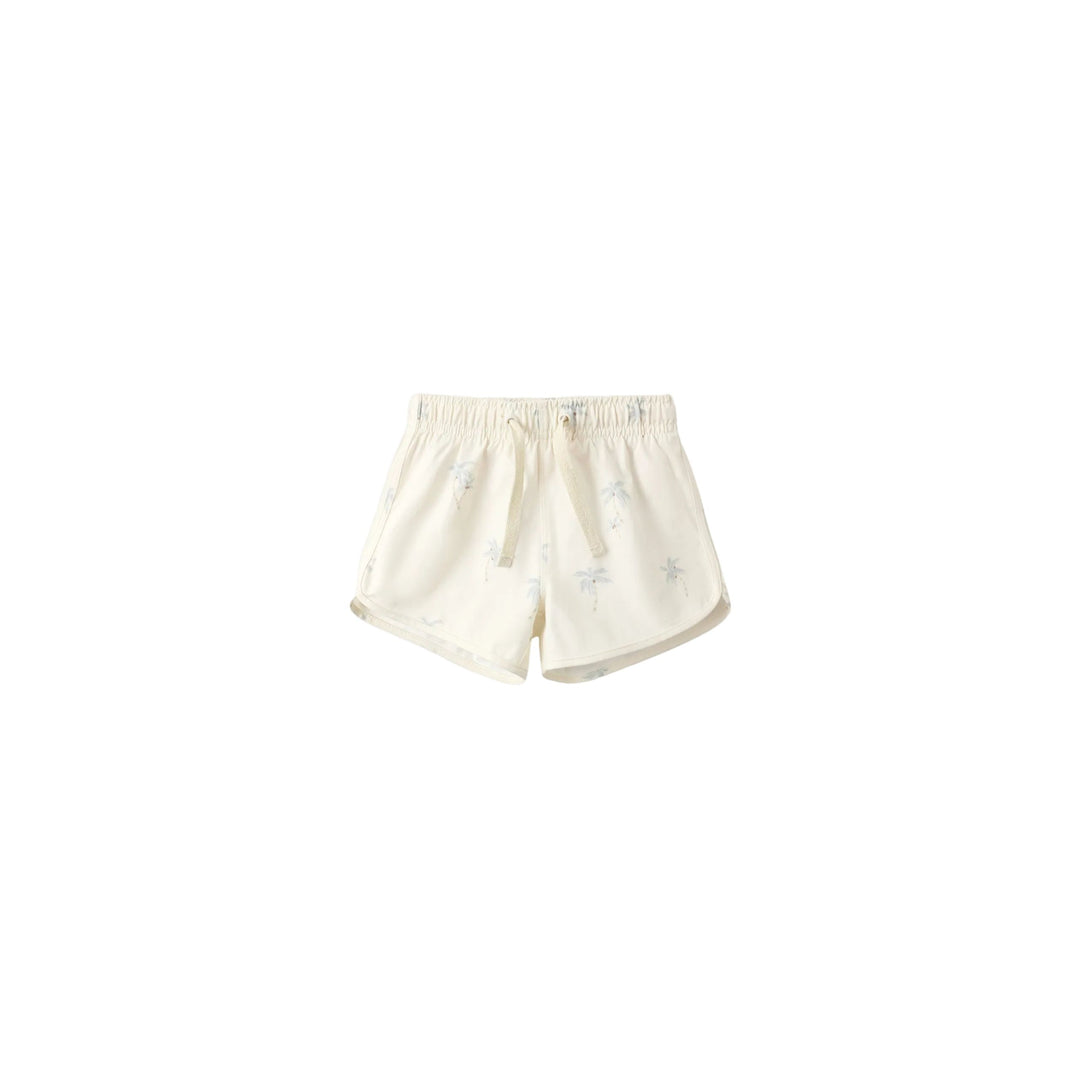 White shorts with a palm tree print on a light gray background