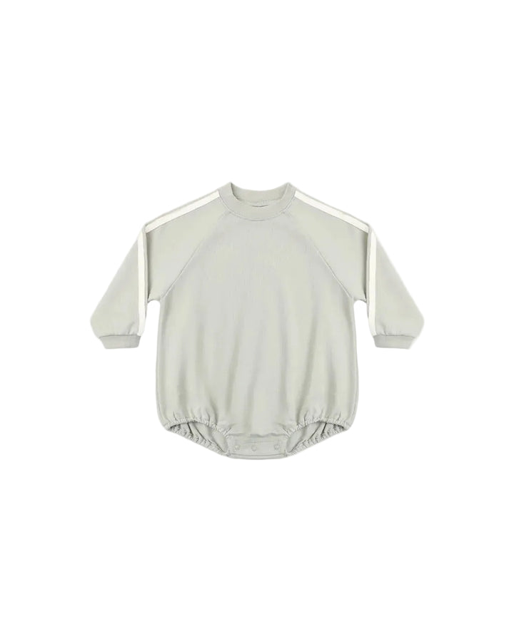 A light sage green long-sleeve baby romper with white shoulder stripes, laid flat against a light background.