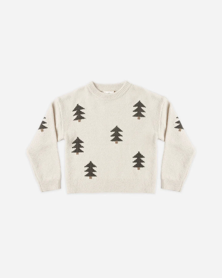 An off-white knit sweater featuring a pattern of dark brown pine trees, laid flat against a light gray background.