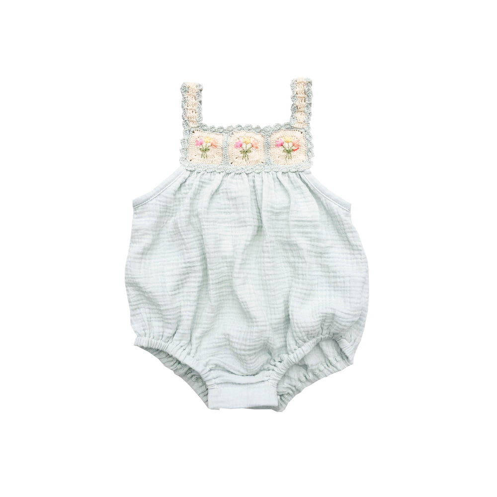 Baby romper with floral lace top on a white background
