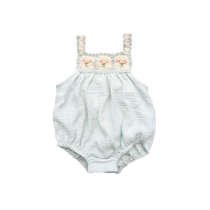 Baby romper with floral lace top on a white background