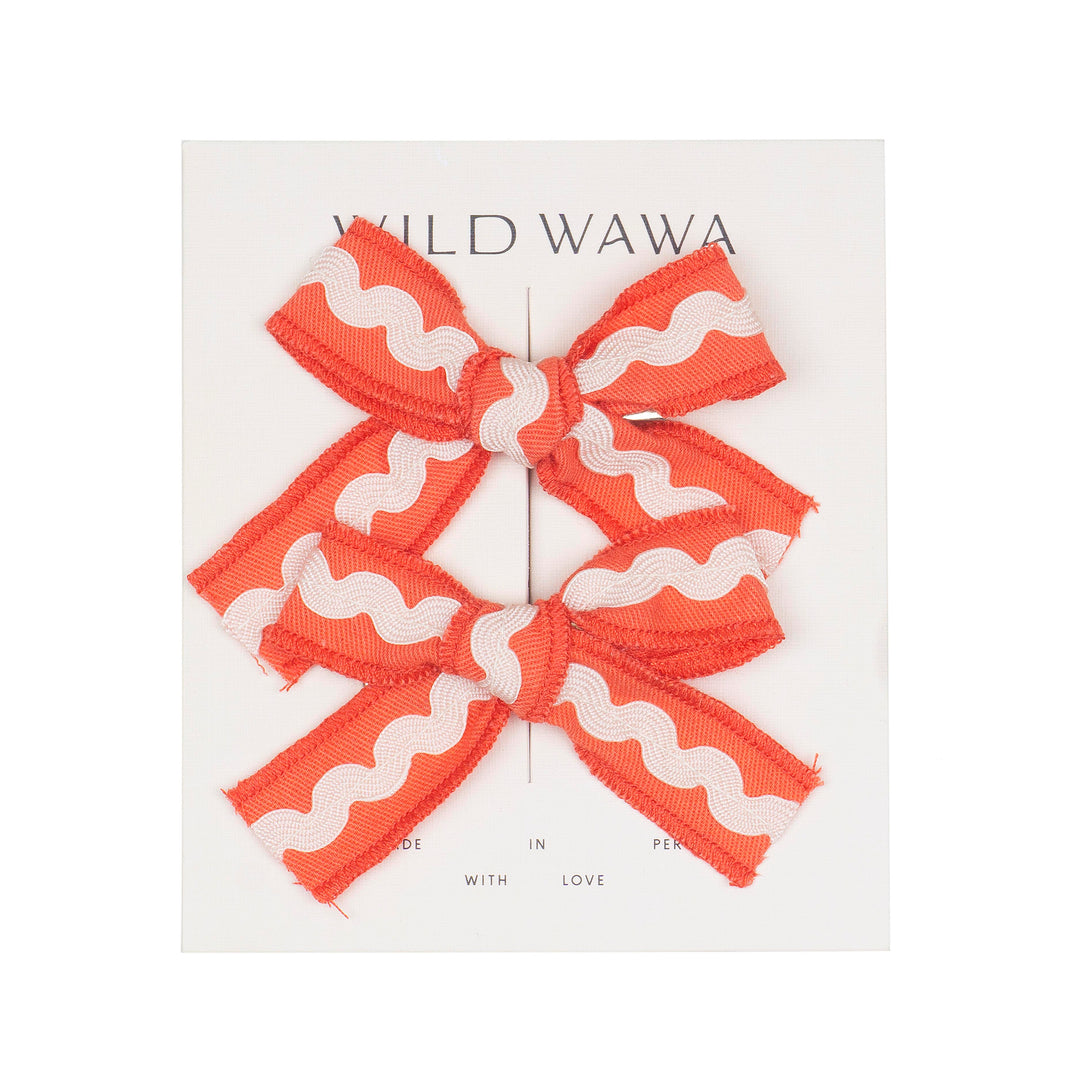 Red and white ric rac bow on a white background with 'Wild Wawa' branding.