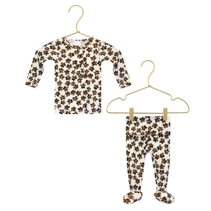 Floral-patterned shirt and pants on hangers with a close-up of the pattern.