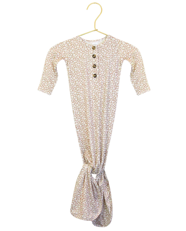 A knotted gown for babies with a floral pattern, displayed with a close-up of the fabric texture.