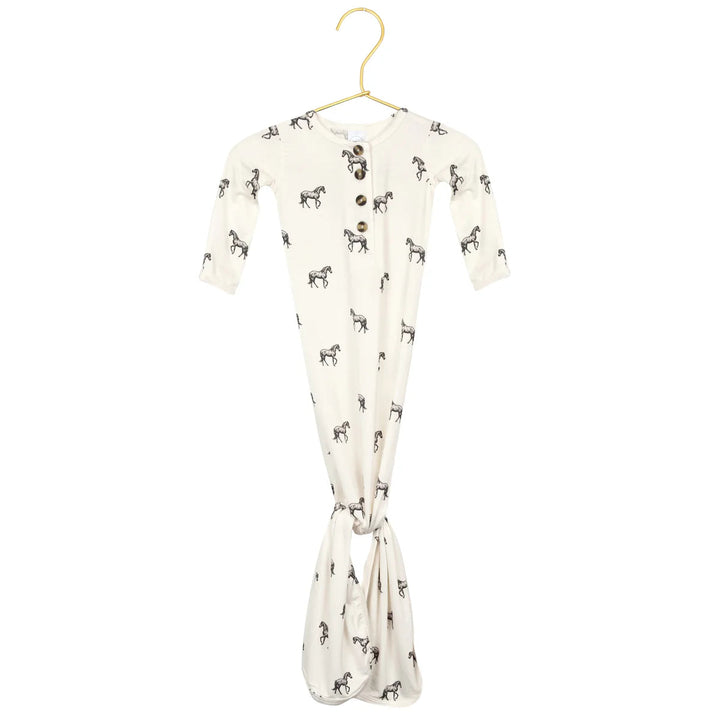Baby wrap with horse pattern on a hanger against a white background